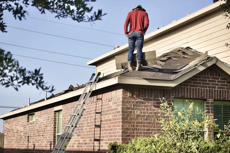 Professional roofer working on a residential roof in Arcola